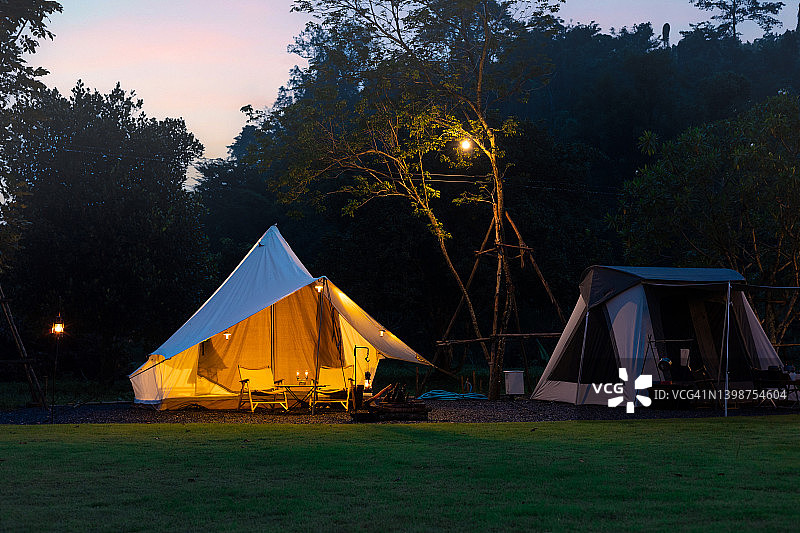 夜晚树影下的照明帐篷图片素材