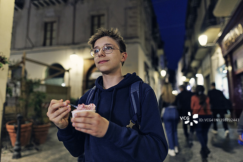 青少年男孩在西西里岛切法卢镇享用一杯冰淇淋图片素材
