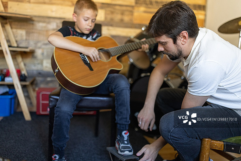 男音乐老师教男孩弹吉他图片素材
