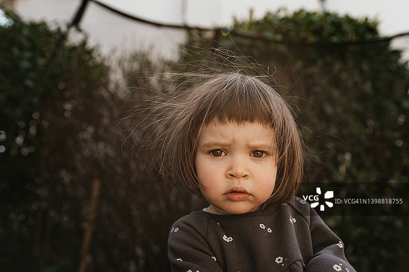 头发蓬乱的皱眉幼儿特写肖像图片素材