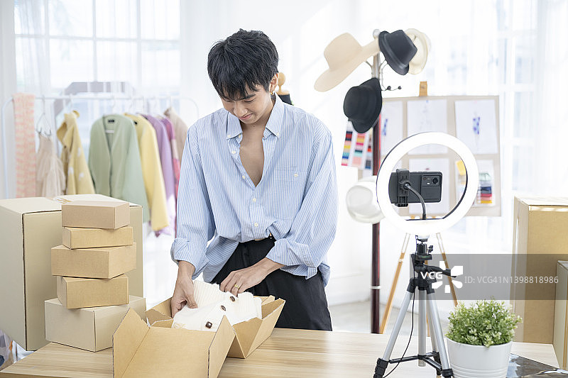 商店里的青年男子。为顾客进行在线销售和商品打包图片素材