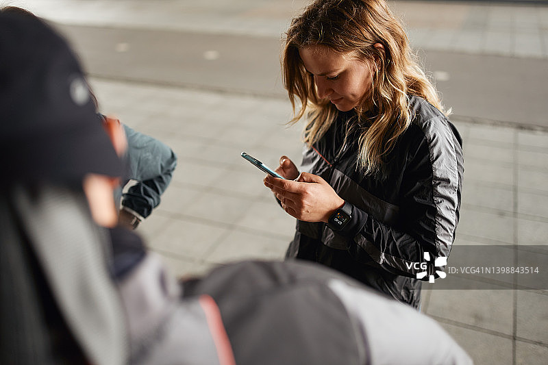训练开始前看智能手机的女运动员图片素材