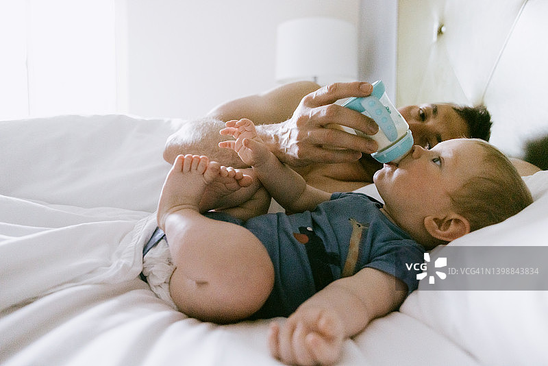 父亲用奶瓶给婴儿喂奶粉图片素材