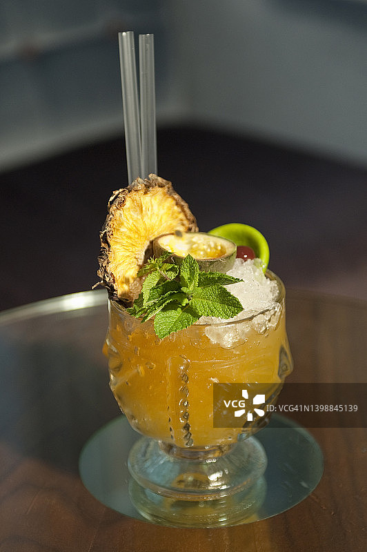 含菠萝干和薄荷叶的黄色鸡尾酒图片素材