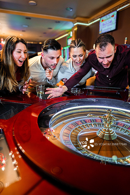 一群兴奋的朋友在赌场玩轮盘赌图片素材