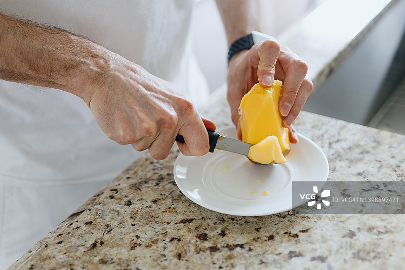 男人切芒果当零食图片素材