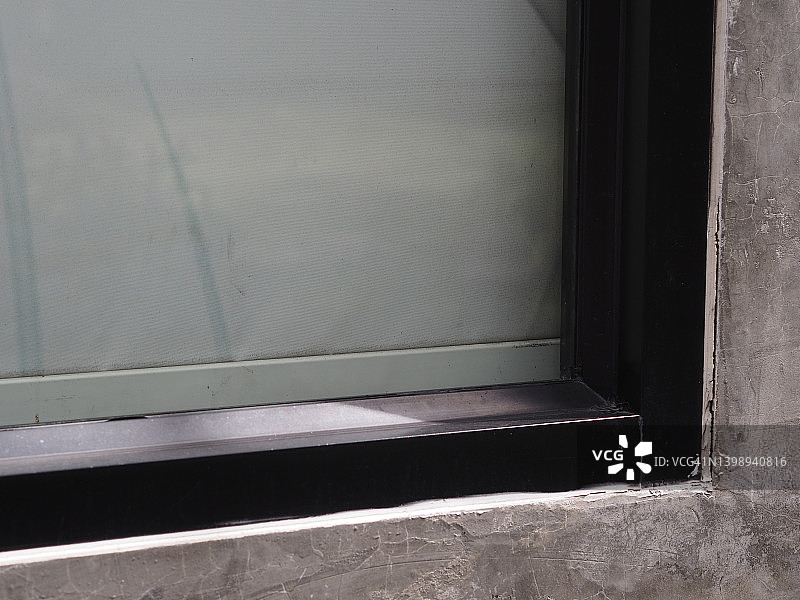 安装在水泥墙上的黑色铝合金窗框图片素材