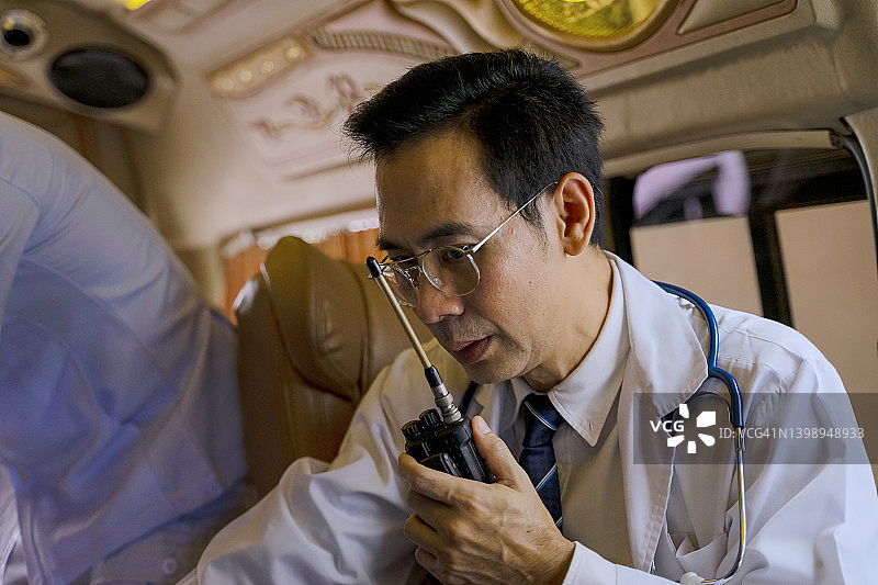 医生在救护车上为病人检查，有助手陪同图片素材