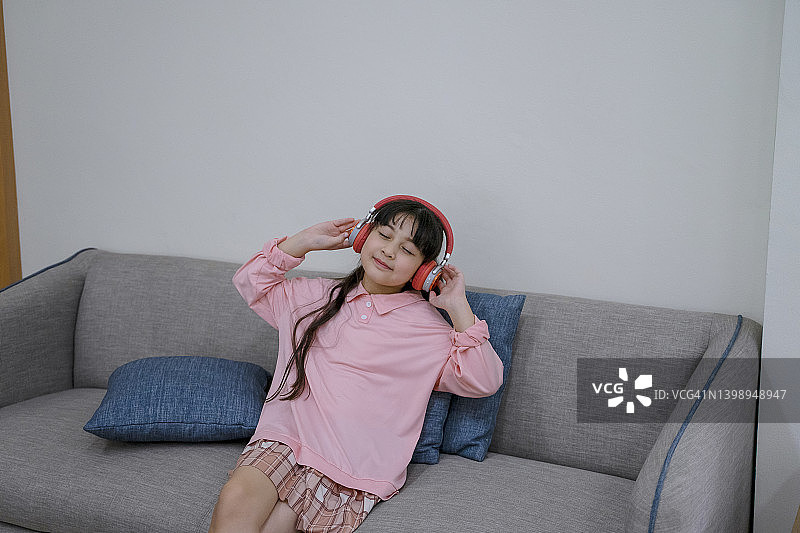 小女孩戴无线耳机听音乐图片素材