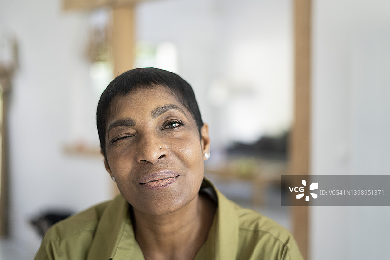微笑的中年妇女在眨眼图片素材