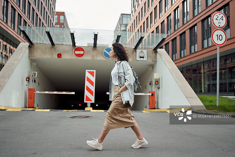 年轻女子在城市街道上行走图片素材