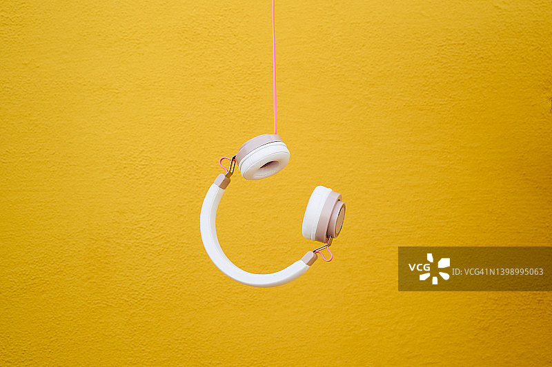 黄色背景中的悬挂耳机图片素材