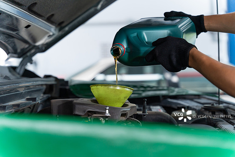 汽车修理工为汽车发动机加油图片素材