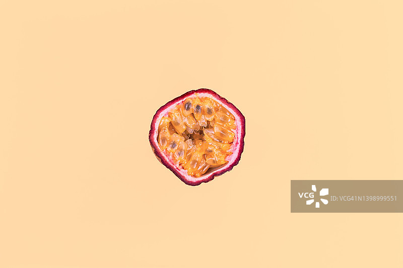 橙色背景上的对半切百香果图片素材
