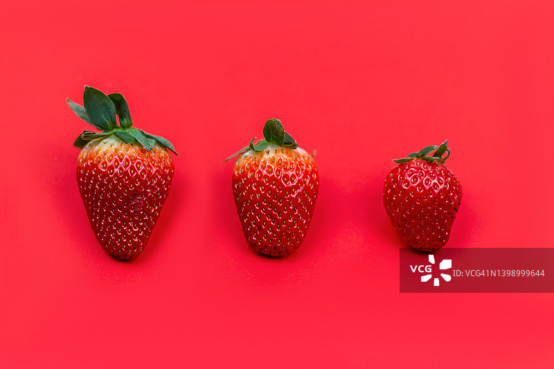 红色背景上的一组草莓图片素材