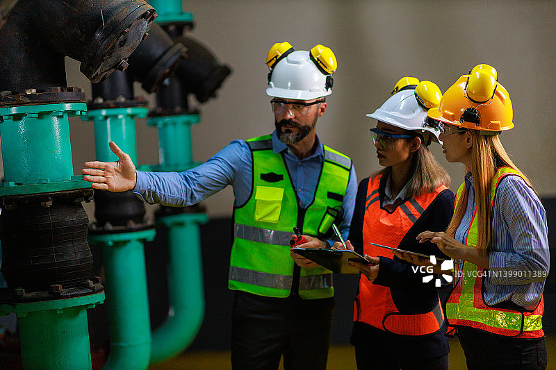 制造工厂中三个工程师一起讨论图片素材