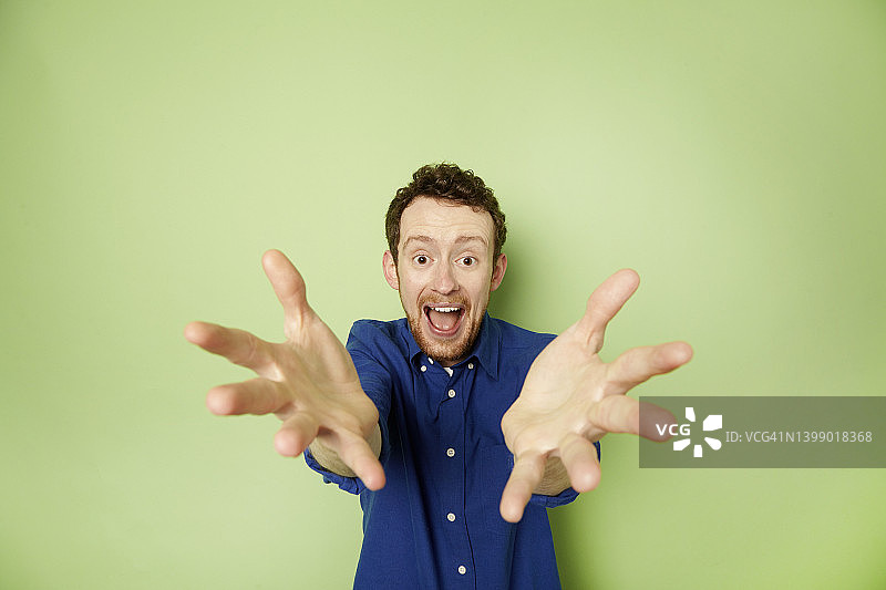 男人欣喜若狂地向镜头伸手图片素材