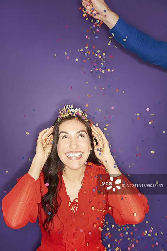 女人被五彩纸屑洒中图片素材