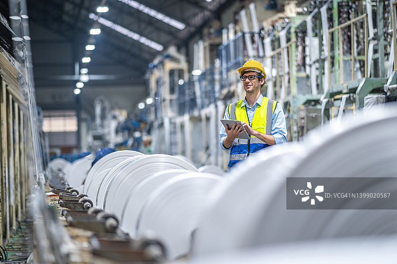 工程师在塑料袋制造商处工作，使用平板电脑图片素材