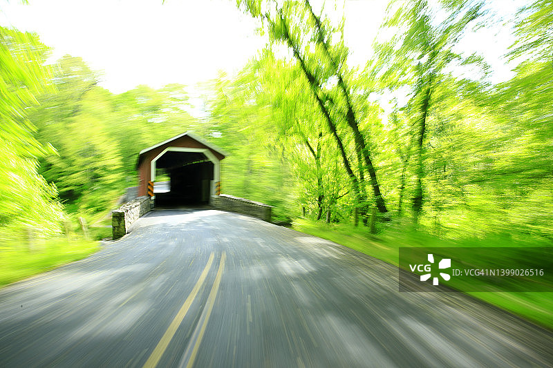 在乡村道路上行驶的老式廊桥图片素材