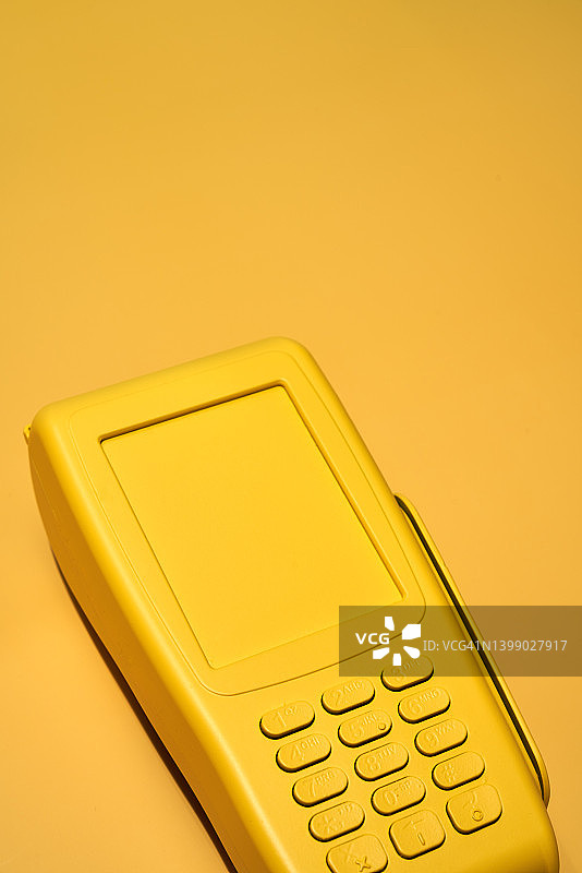 黄色背景上的黄色信用卡POS机终端图片素材