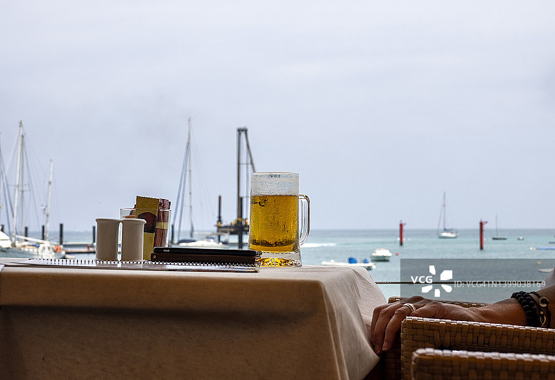 海边餐厅的室外露台，桌上放着一杯啤酒图片素材