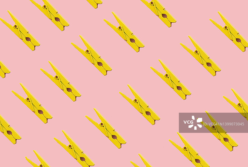 粉色背景上的黄色晾衣夹图案图片素材