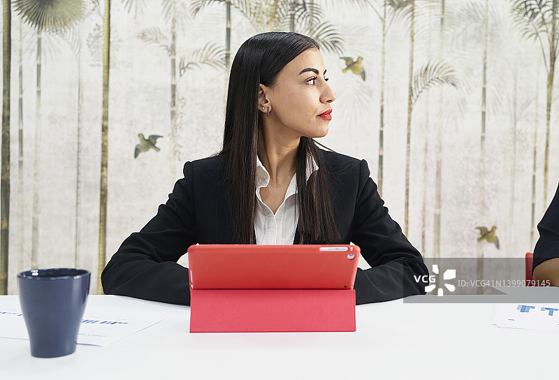 拉丁裔女子使用红色封面的平板电脑图片素材