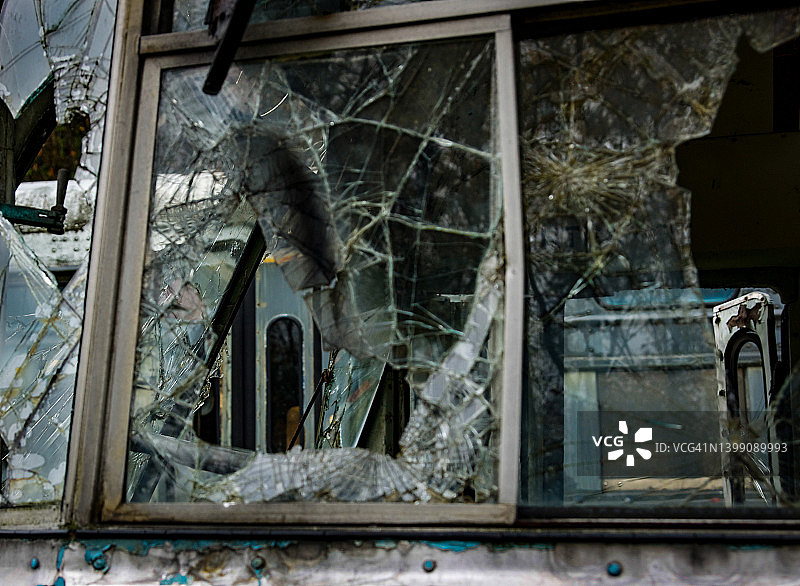 从破碎的窗户望向损毁的巴士图片素材