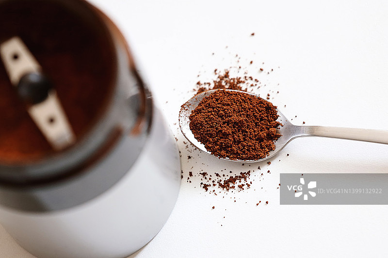 电动咖啡研磨机和一勺有机阿拉比卡咖啡豆图片素材