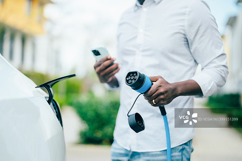 男人给电动汽车充电图片素材