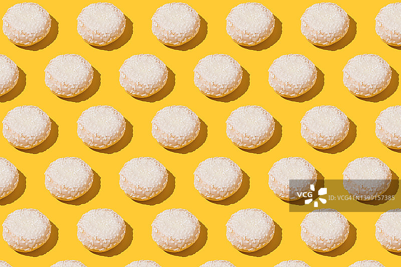 黄色背景下的奶油白巧克力柏林甜甜圈图案，甜点、饼干、肥胖、糖和饮食的概念图片素材
