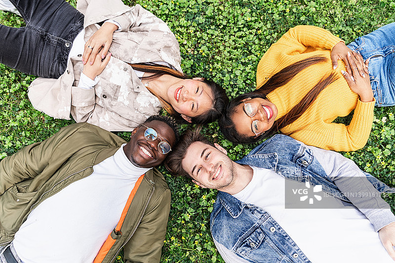 躺在草地上的多民族大学生朋友图片素材