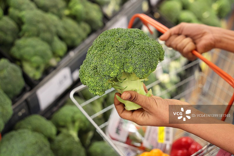 在超市购物，选择西兰花图片素材