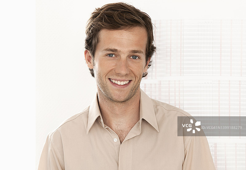 一位年轻的商务男士的肖像，面带微笑直视镜头图片素材