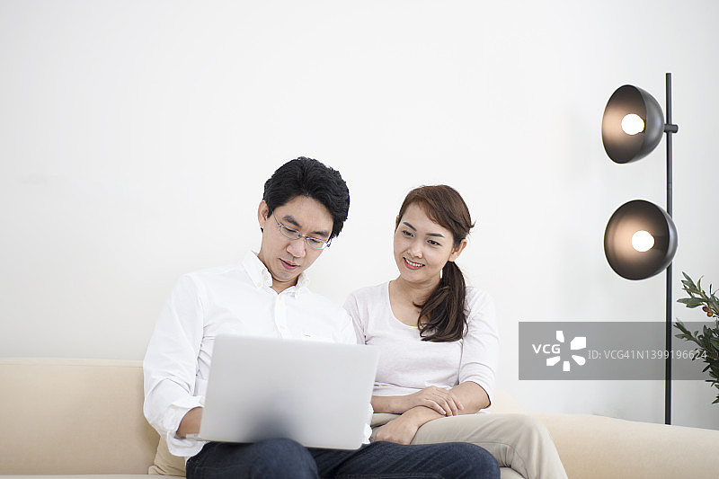 年轻夫妇在家使用电脑图片素材