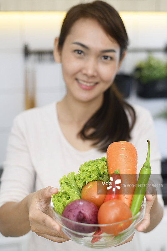 女人手持新鲜蔬菜图片素材