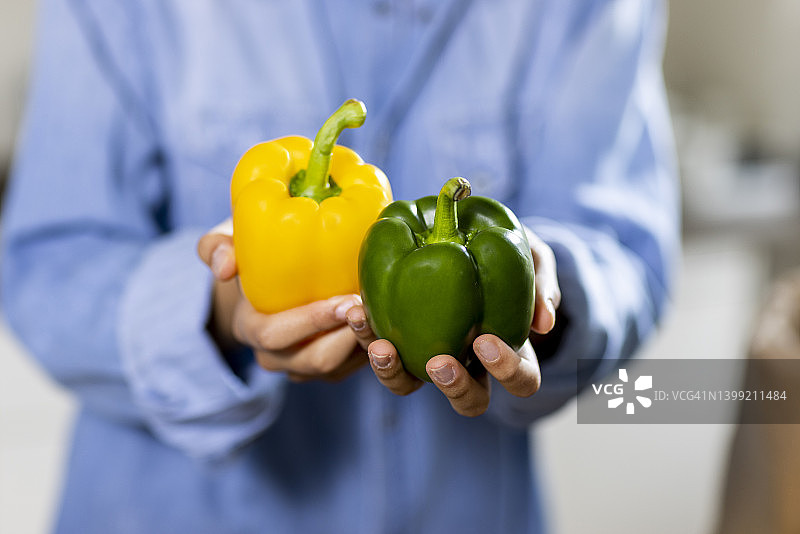 年轻女子手持黄绿甜椒图片素材