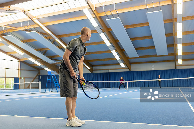打网球时发球的中年男人图片素材