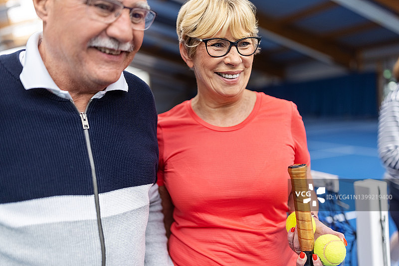 快乐的老年夫妇在网球场散步图片素材
