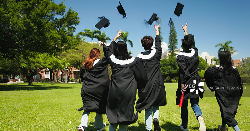 一群快乐的毕业生抛帽子庆祝图片素材