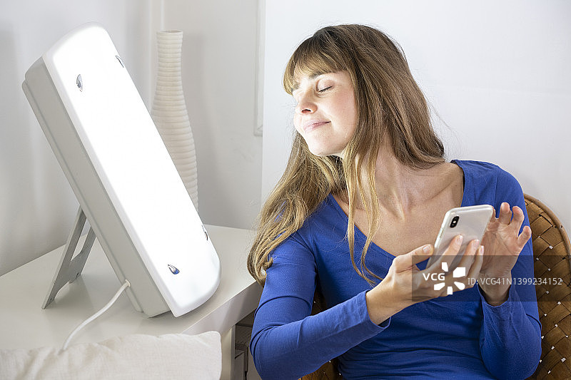 女人用智能手机进行光疗图片素材