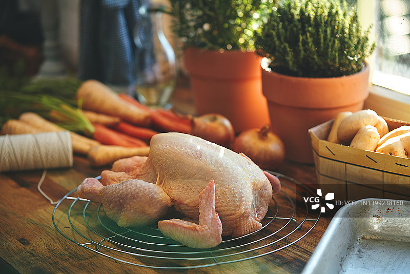 在家庭厨房准备烤鸡和根类蔬菜图片素材