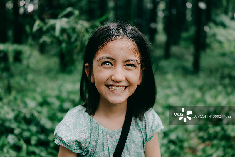 年轻女孩在森林里对着镜头微笑图片素材