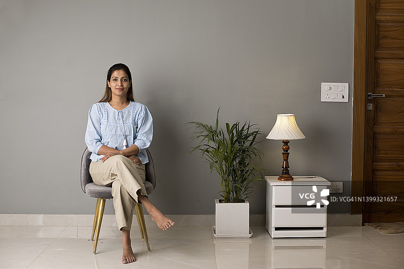 坐在现代住宅椅子上的快乐女人图片素材