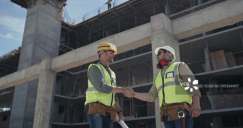 建筑工人在建筑工地握手达成协议图片素材