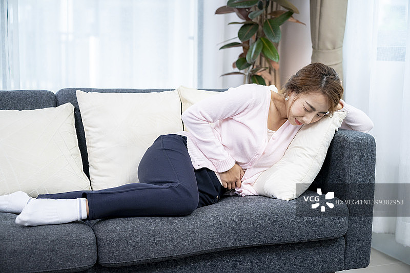 在沙发床上胃痛的女人图片素材