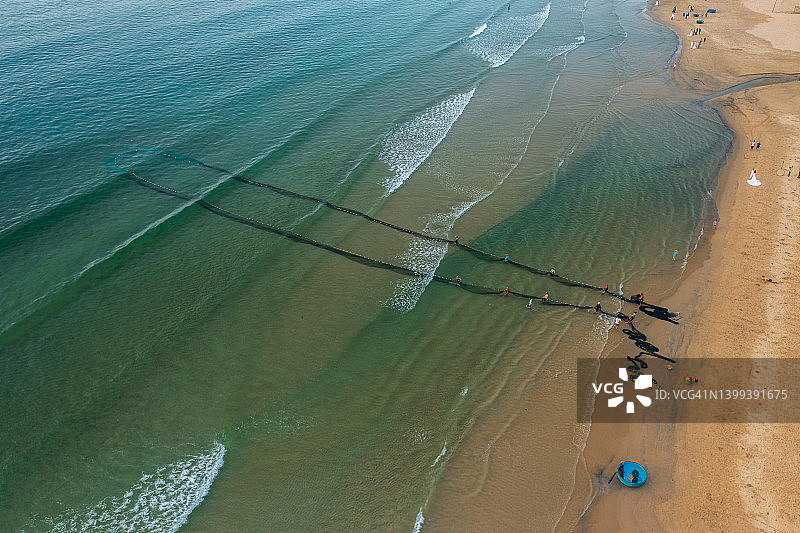 在海滩上拉网的渔民图片素材