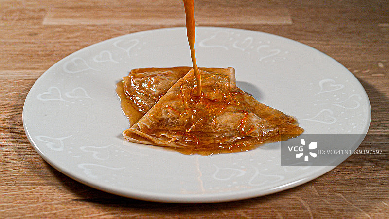 淋在盘中折叠薄饼上的苏泽特酱图片素材