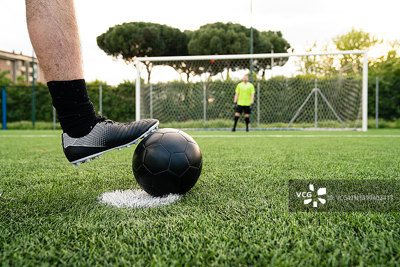 成年男子正在摆放足球准备进行点球射门图片素材